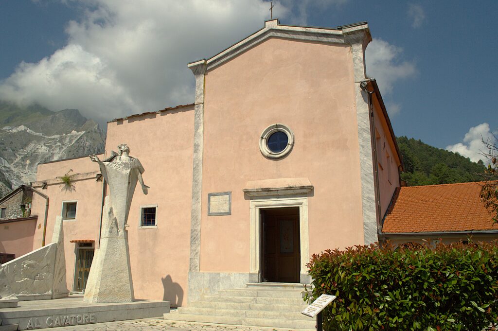 Façade de l'église de Colonnata avec un monument dédié aux carriers